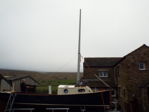 The mast in place, temporary clamps on, ready for the rubber to be poured. - and the weather closing in!